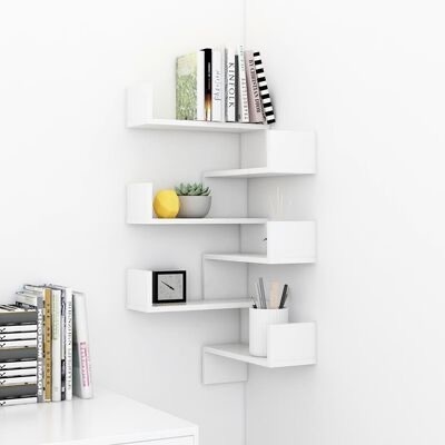 Estante de canto branca com livros, planta, relógio e lápis numa parede branca