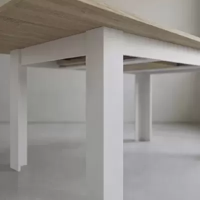 Mesa de madeira clara com pernas brancas e retangulares