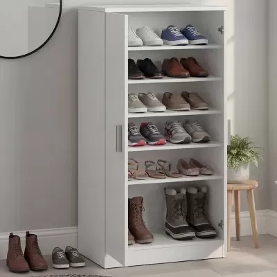 Móvel branco para arrumação de sapatos em ambiente interior com vários calçados distintos organizados nas prateleiras.