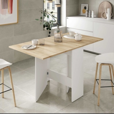 Mesa de jantar retangular em madeira clara e branco num ambiente de cozinha moderna com bancos altos e decoração