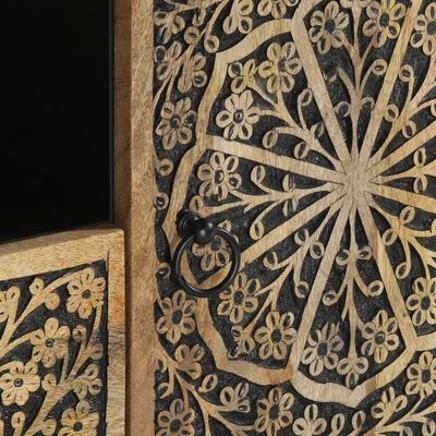 Detalhe de móvel de madeira com padrão floral gravado e ferragens metálicas pretas