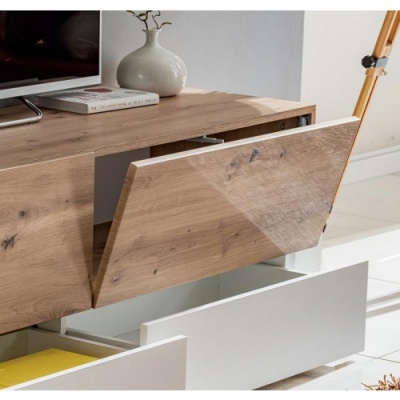 Móvel de televisão em madeira clara com compartimentos e decoração simples