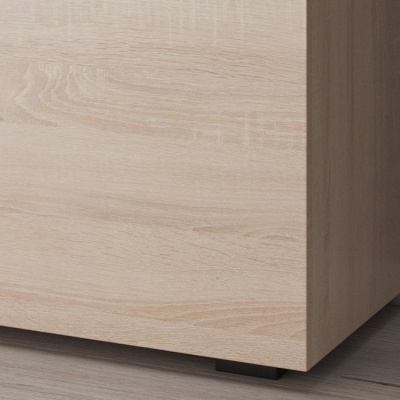 Móvel em madeira clara com suporte preto e piso cinza