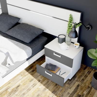 Mesa de cabeceira branca com gavetas cinzentas ao lado de cama com roupa de cama cinzenta