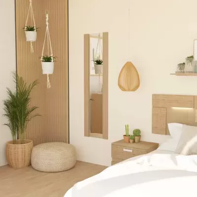 Quarto decorado com cama branca, mesa de cabeceira de madeira clara, plantas e candeeiro de ripas de madeira.