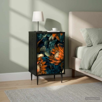 Mesa de cabeceira em madeira com gavetas decoradas com padrão floral laranja e azul ao lado de cama com almofadas cinza claro