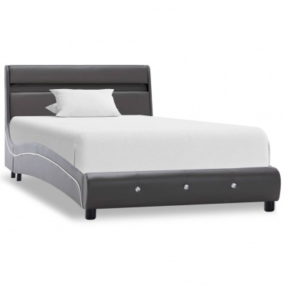 Cama de solteiro cinzenta escura estofada com roupa de cama branca e uma almofada