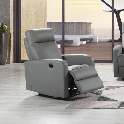 Poltrona reclinável cinzenta em pele sintética numa sala com chão claro e tapete geométrico.