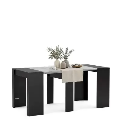 Mesa conversível com tampo branco e pés negros decorada com vasos, plantas e velas