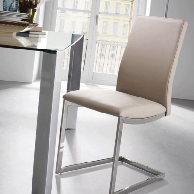 Cadeira bege claro com estrutura metálica e mesa de vidro num espaço interior