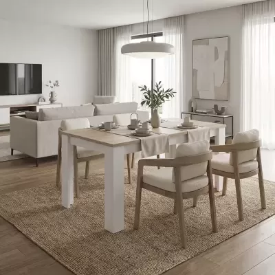 Sala de jantar com mesa branca, cadeiras de madeira clara estofadas em bege, sofá e decoração neutra