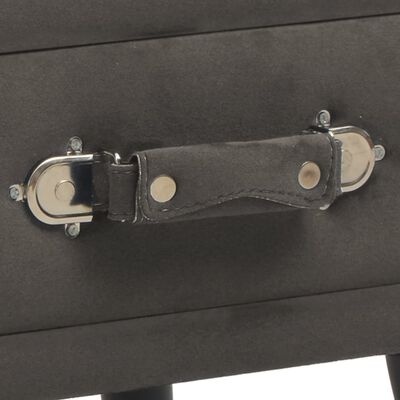 Alça reforçada em tecido preto com botões metálicos numa mala ou caixa preta.