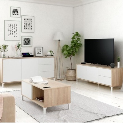 Sala de estar com móveis de madeira clara e branco, plantas, candeeiro de pé e quadros decorativos nas paredes