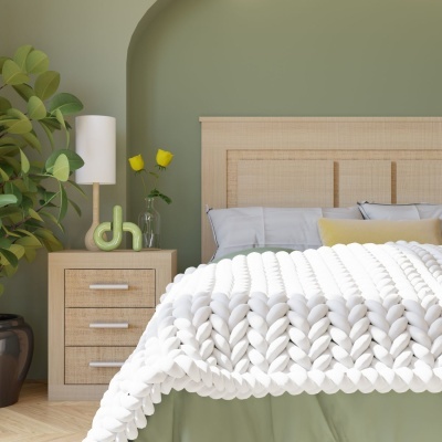 Quarto com cama, cabeceira de madeira, colcha branca e mesa de cabeceira com decoração