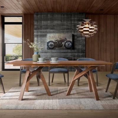 Mesa de jantar em madeira com cadeiras azuis e quadro de motocicleta na parede