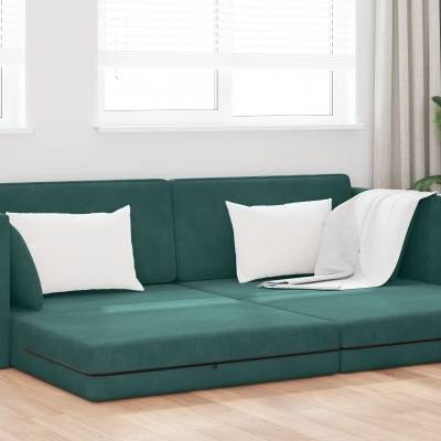 Sofá modular verde escuro com almofadas brancas e manta numa sala clara