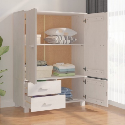 Guarda-roupa branco aberto com roupas e almofadas organizadas