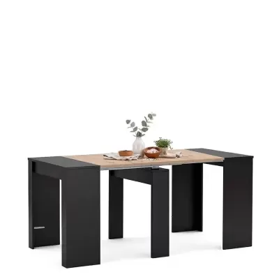 Mesa extensível em madeira clara e preto com decoração de plantas e tigelas
