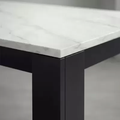 Mesa com tampo de mármore branco e pernas em metal preto.
