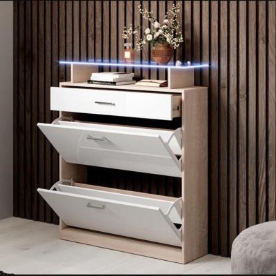 Sapateira de madeira clara com portas brancas e decoração com flores, livros e perfume