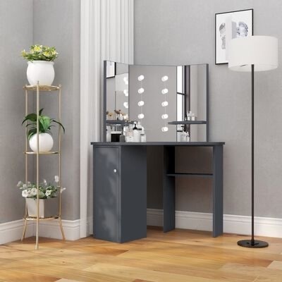 Mesa de maquilhagem cinzenta com espelhos num quarto com candeeiro de pé e estante com plantas
