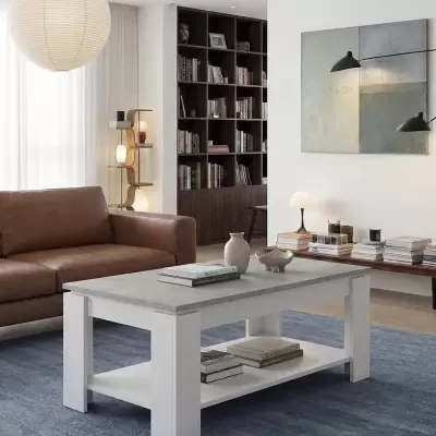 Mesa de centro com tampo cinza e estrutura branca numa sala moderna com sofá castanho e estante de livros