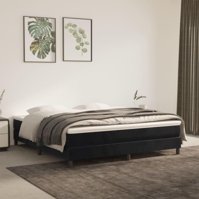 Cama de casal com roupa de cama cinza e almofadas brancas, dois quadros com folhas verdes e cortina cinza escura