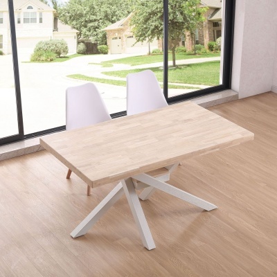 Mesa de jantar com tampo de madeira clara e base branca, com duas cadeiras brancas junto a janela