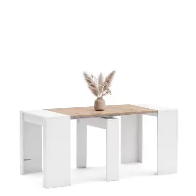 Mesa de jantar extensível com tampo em madeira clara e pernas brancas decorada com vaso de barro e flores secas.