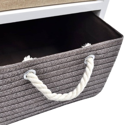 Cesto cinzento trançado com alças de corda inserido em estante branca