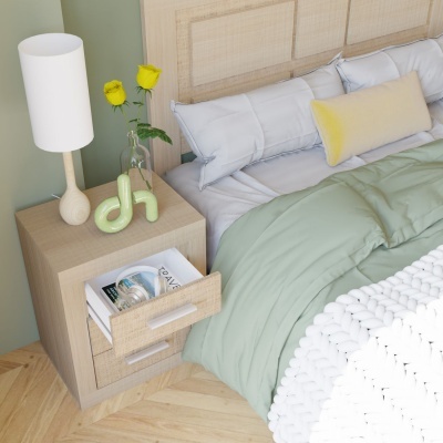 Quarto com cama, almofadas, candeeiro, vaso com flores amarelas e móvel de cabeceira em madeira clara