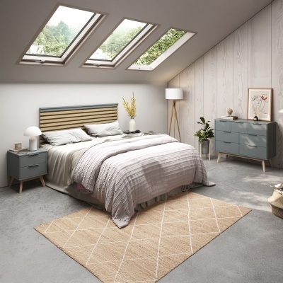 Quarto com cama de madeira, mesas de cabeceira cinzentas, candeeiro de pé branco, cómoda e parede em madeira clara