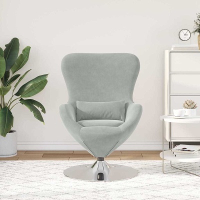 Cadeira de leitura cinzenta com almofada, em ambiente de sala com planta, móvel branco e mesa redonda.
