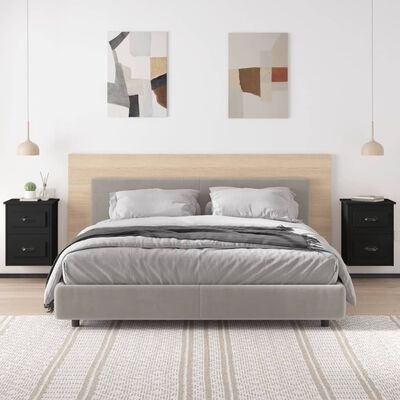 Quarto com cama de casal cinza, cabeceira de madeira, mesinhas pretas suspensas, carpete branco e duas pinturas abstratas.
