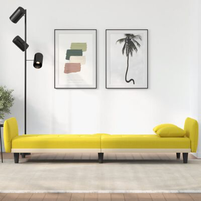 Sofá amarelo comprido com almofada numa sala minimalista com quadros e candeeiro de pé