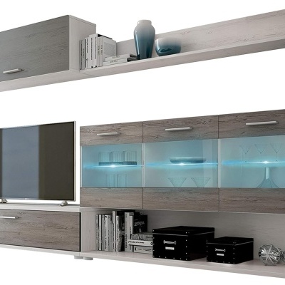 Móvel de sala de estar em madeira cinzenta com portas em vidro iluminadas, decorado com livros, caixas e televisor.