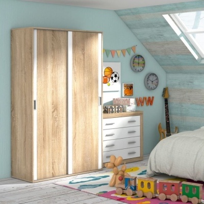 Quarto infantil com armário de madeira clara, cómoda branca, decoração de parede e brinquedos coloridos no tapete.