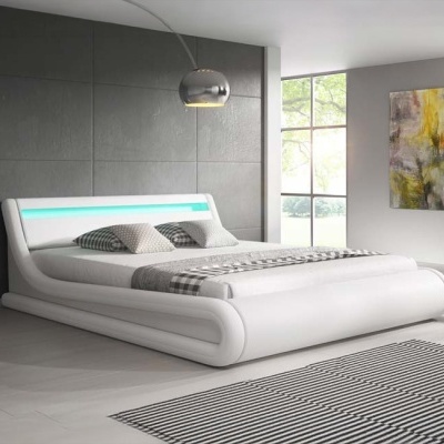 Cama branca estofada moderna com luz azul na cabeceira, roupa de cama cinzenta e branca, candeeiro metálico e tapete riscado