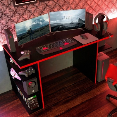 Setup de gaming com dupla monitorização, teclado, rato, auscultadores e comandos em mesa preta com luzes vermelhas