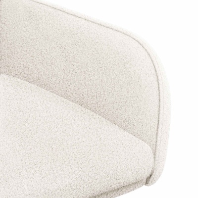 Detalhe do tecido bouclé branco com textura felpuda e costura na borda de um móvel estofado.