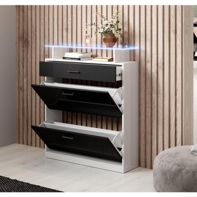 Armário de sapatos branco com portas pretas basculantes e gaveta superior, em ambiente interior moderno