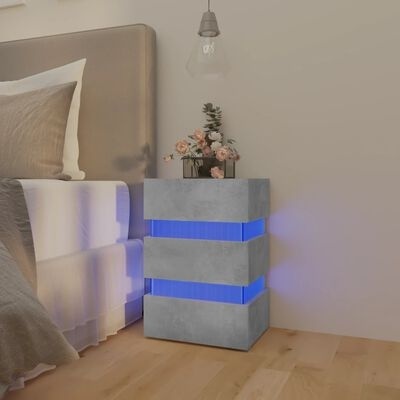 Mesa de cabeceira cinza com faixas luminosas azuis junto a cama