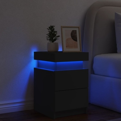 Mesa de cabeceira preta com luz azul, planta e moldura ao lado de cama cinzenta