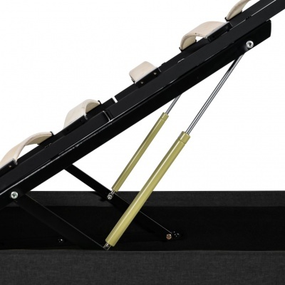 Estrutura metálica preta com amortecedores hidráulicos dourados e almofadas bege