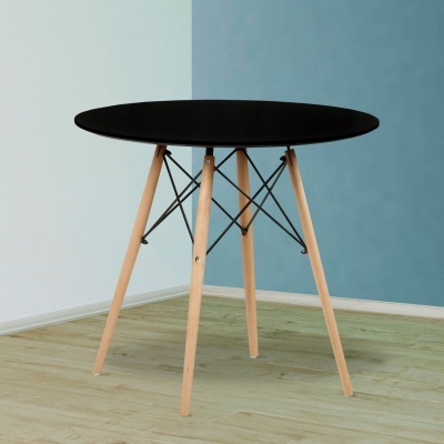 Mesa redonda preta com pernas de madeira clara e suporte metálico em ambiente de paredes azuis