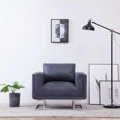 Poltrona cinzenta escura com pernas metálicas em ambiente minimalista com elementos decorativos