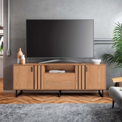 Televisão preta sobre consola de madeira clara com decoração minimalista.