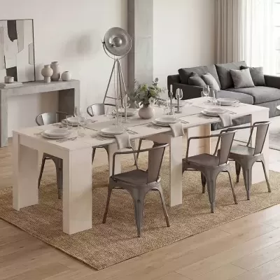 Mesa de jantar branca com cadeiras metálicas cinza e decoração, em sala com sofá cinza e tapete bege