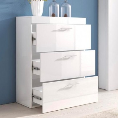 Móvel branco com três gavetas, duas abertas, decorado no topo com frascos e vaso, contra parede azul