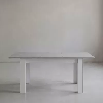 Mesa retangular cinzenta com pernas brancas em ambiente minimalista